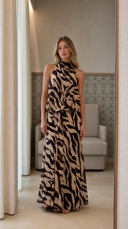 Front view of model wearing beige animal print halter neck maxi dress