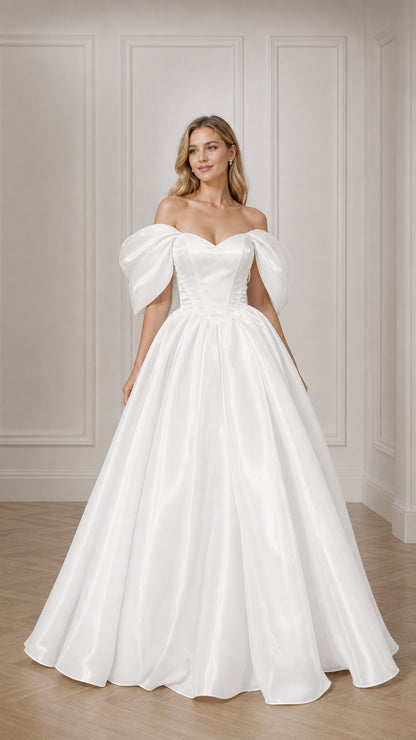 Front view of woman wearing white off-the-shoulder puff sleeve satin ball gown