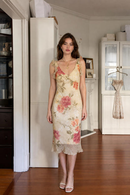 Front view of woman wearing cream floral ruffle midi dress