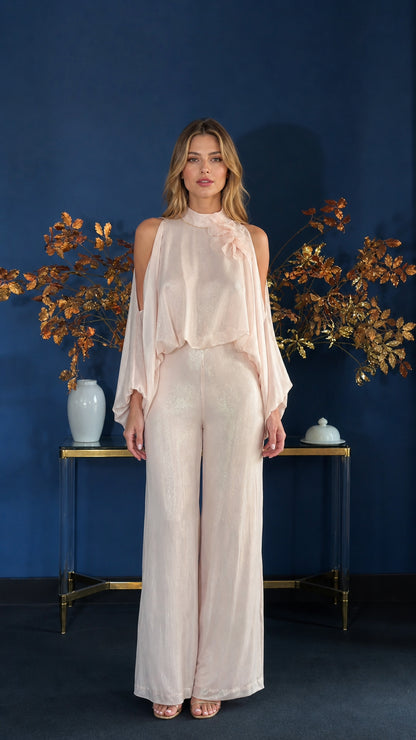 Front view of model wearing champagne cold-shoulder overlay jumpsuit