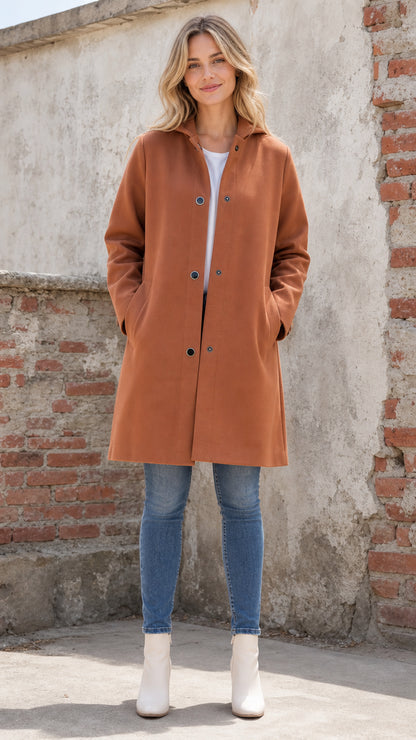 Front full view of woman wearing rust hooded mid-length coat