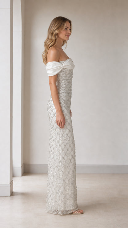 Side profile view of white off-shoulder beaded evening gown