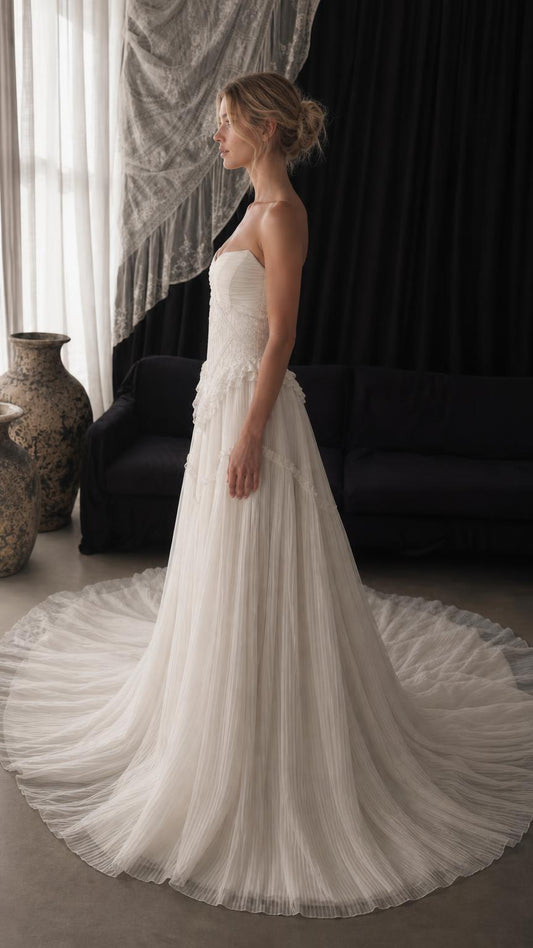 Side profile view of white strapless tulle gown with train