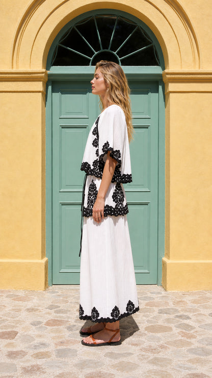 Side profile of model in white embroidered two-piece set