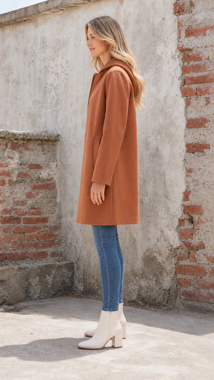 Side profile view of woman wearing rust hooded coat