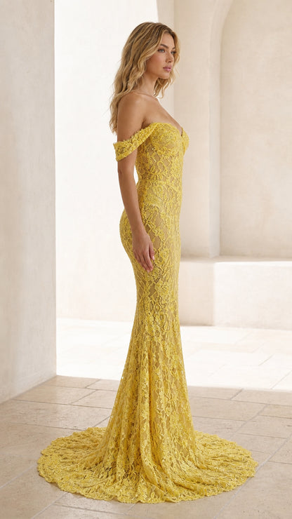 Side profile view of yellow lace evening gown with train