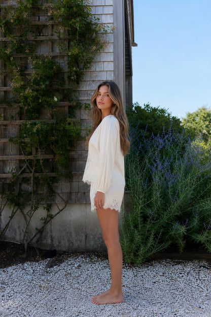 Side view of woman wearing cream lace trim lounge set