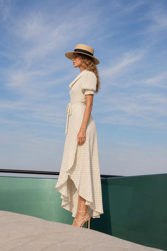 Side view of cream polka dot maxi dress showing asymmetrical hem