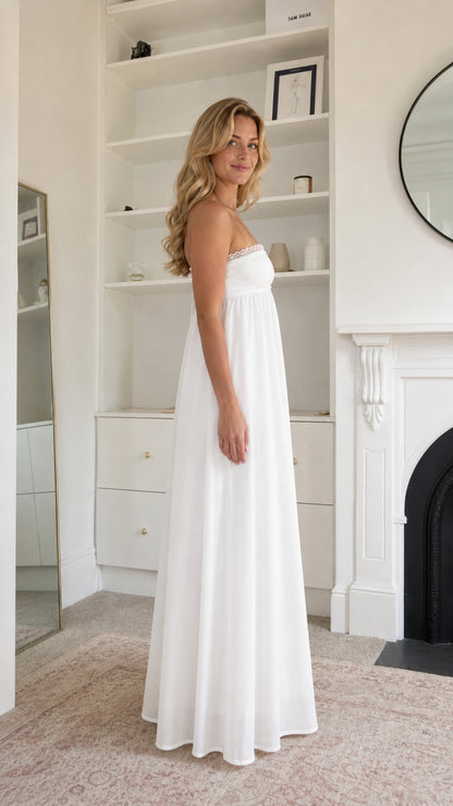 Side profile view of woman wearing white maxi dress