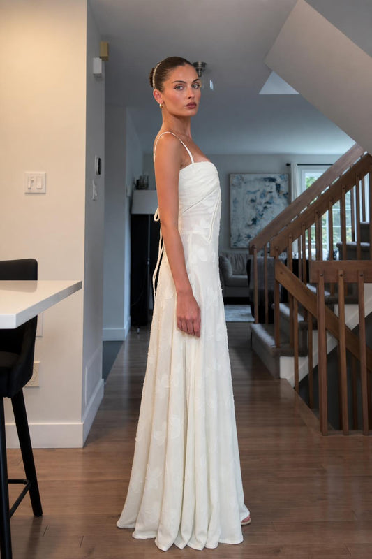 Side profile of woman in white maxi dress