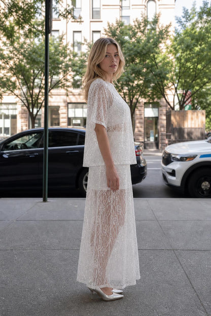Side profile view of woman in white sequin lace matching set