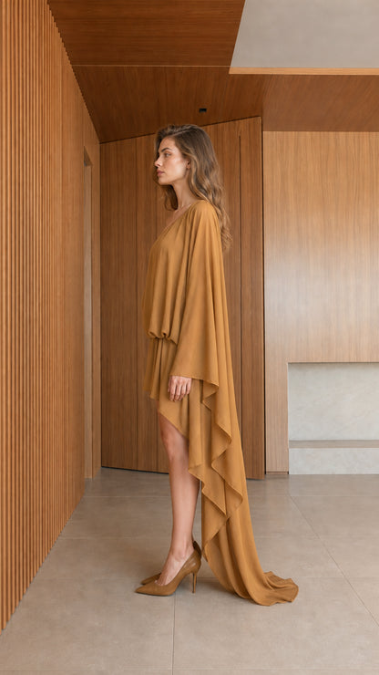 Side profile view of model in camel draped mini dress