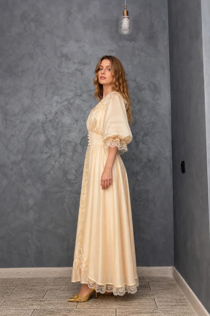 Side profile view of model in cream maxi dress