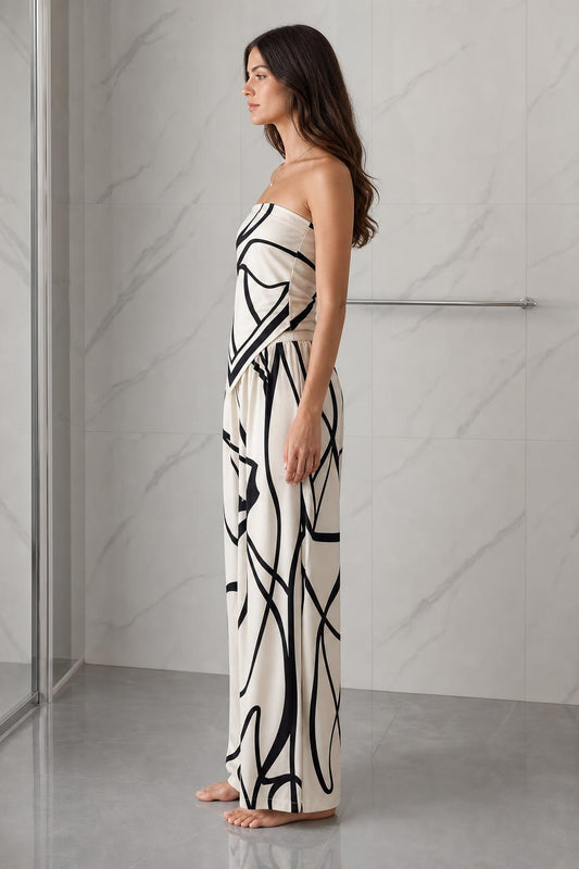 Side profile view of woman wearing beige and black abstract print strapless jumpsuit