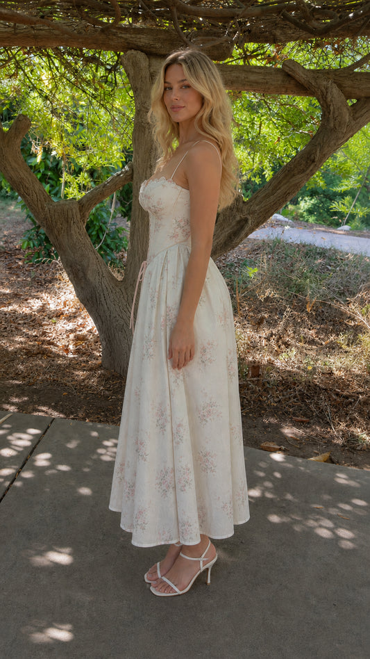 Side profile view of woman in white floral midi dress