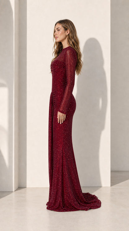 Model wearing burgundy long sleeve glitter evening gown, side view