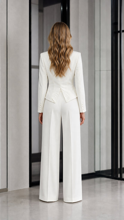 Back view of woman wearing white tailored suit set with flared hem detail