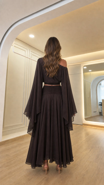 Back view of woman showcasing the draped back design of the dark brown outfit