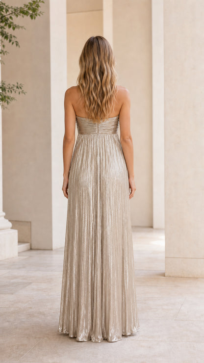 Back view of model wearing gold metallic pleated strapless maxi dress
