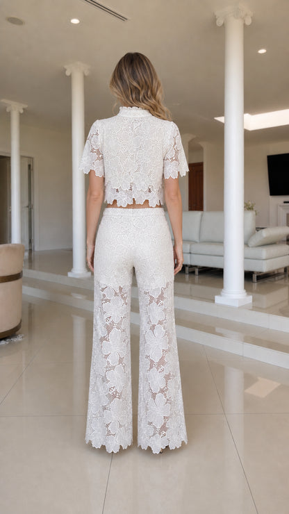 Back view of woman in white lace crop top and trousers