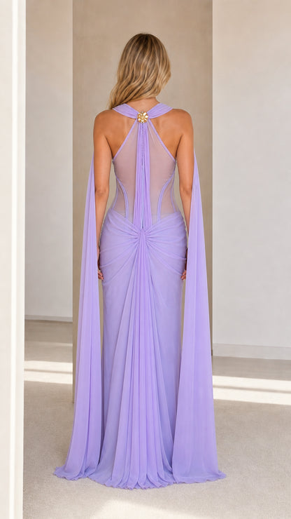Model wearing lavender cape maxi dress back view showing sheer mesh and capes