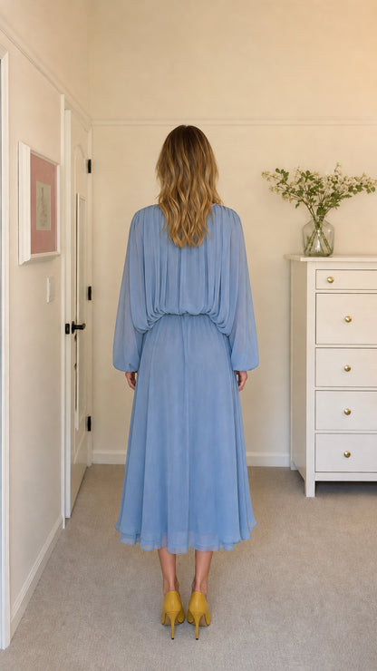 Back view of model in light blue pleated midi dress