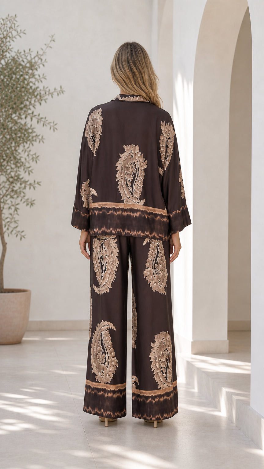 Back view of model showcasing draped fit of brown two-piece set