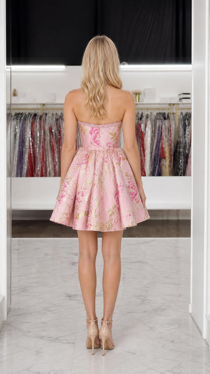 Back view of model showing strapless design of pink mini dress