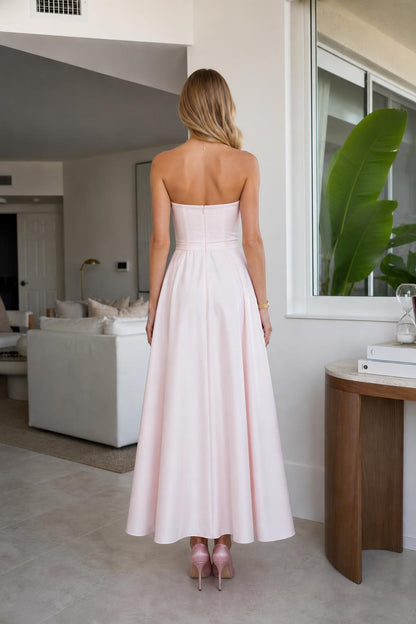 Model wearing pink strapless midi dress, back view