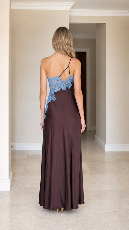 Back view of woman wearing brown one-shoulder satin maxi dress showing strap details