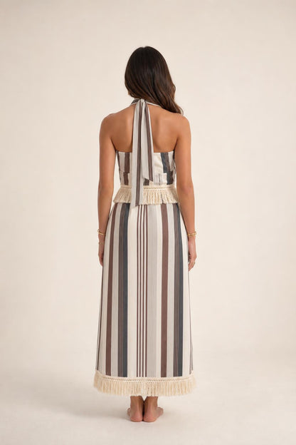 Back view of model wearing beige stripe halter fringe maxi dress