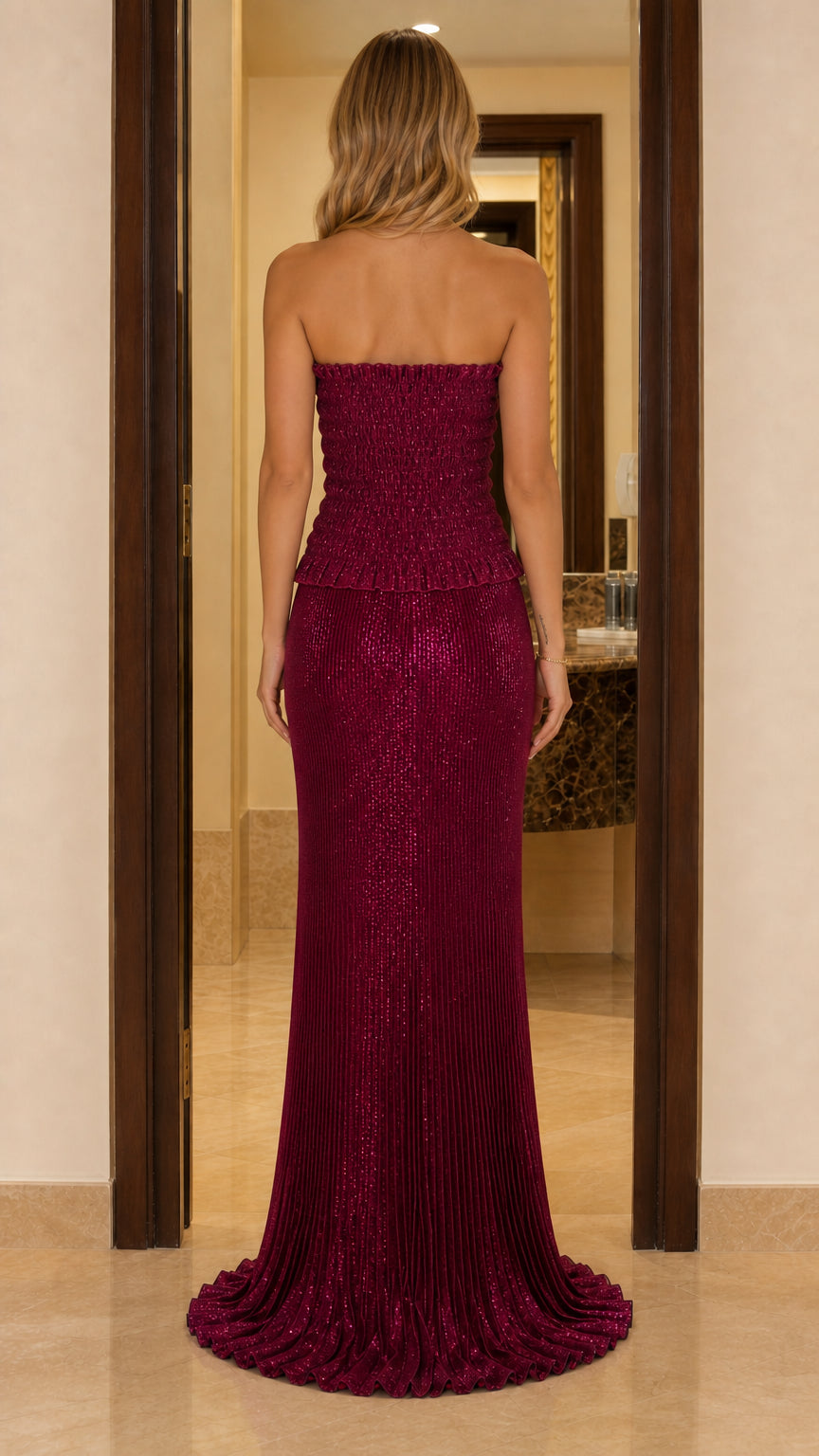 Back view of a burgundy strapless textured maxi dress with a long elegant hem