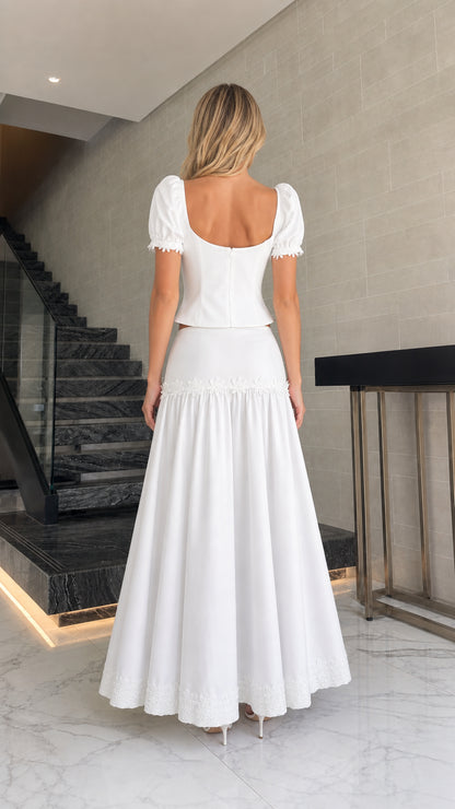 Back view of model in white puff sleeve top and maxi skirt