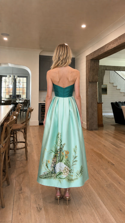 Back view of model in teal and mint strapless evening gown
