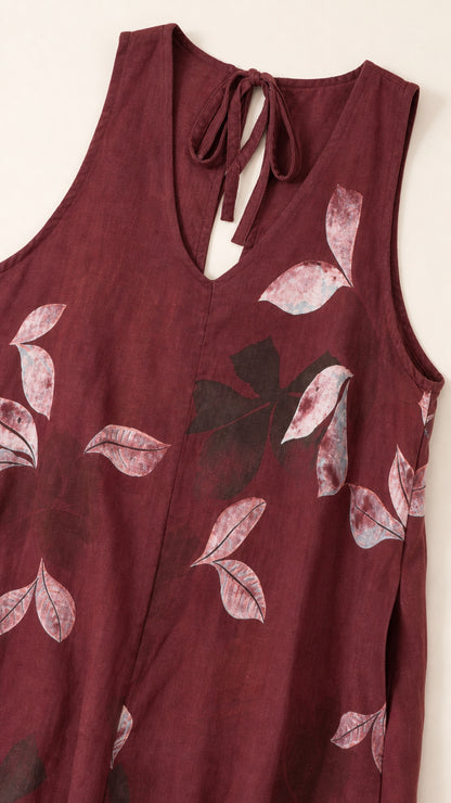 Close-up of V-neck and leaf pattern on burgundy jumpsuit