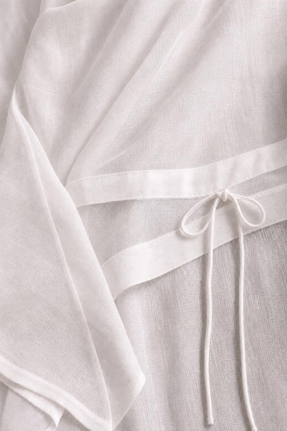 Close-up detail of white textured fabric and adjustable drawstring waist