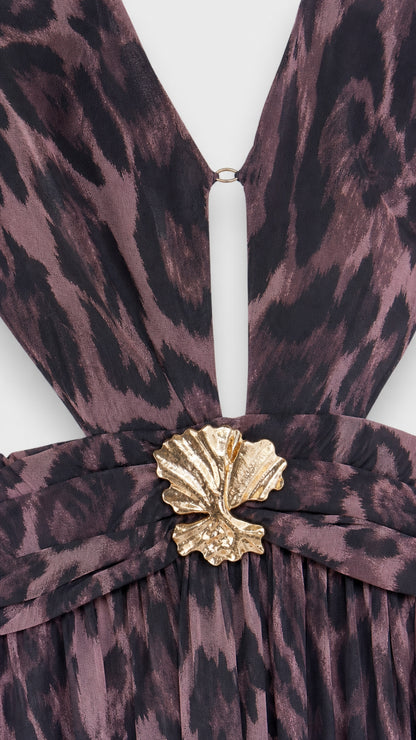 Close-up detail of the plunging neckline, waist cutout, and gold shell hardware