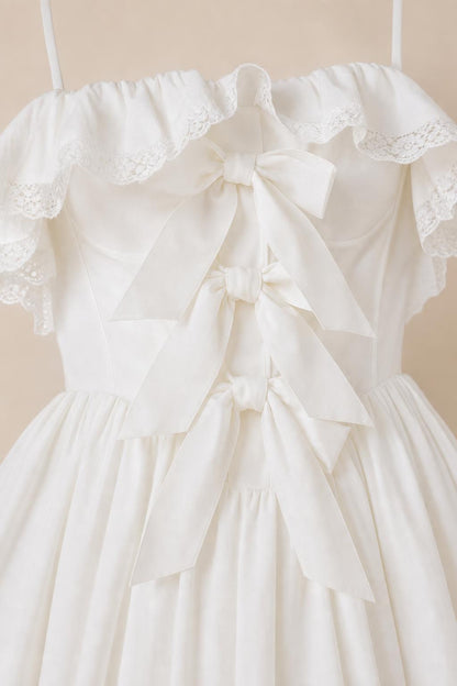 Close-up detail of front bodice bows and ruffles on white dress