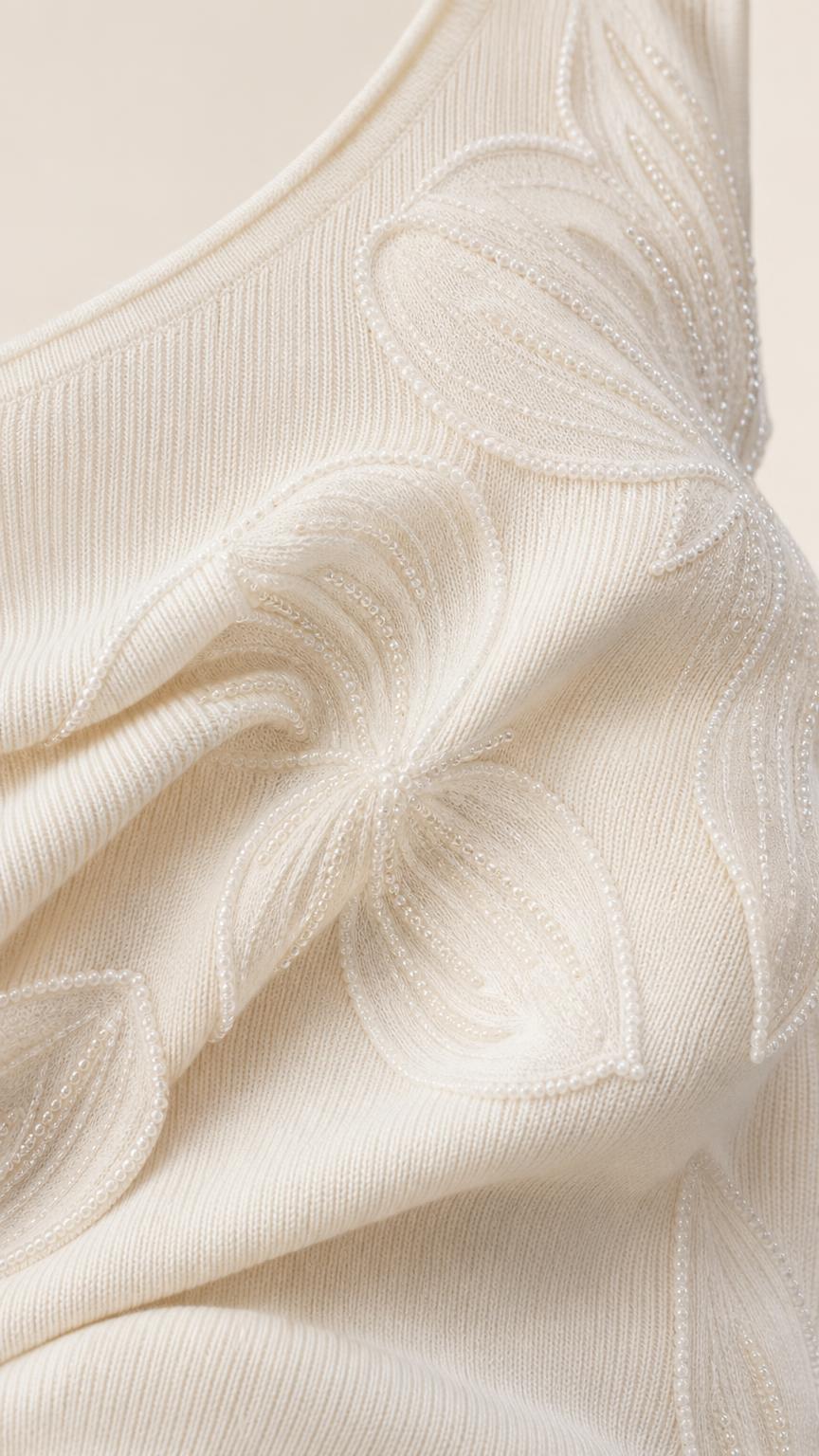 Close-up of textured fabric and floral appliques on white dress