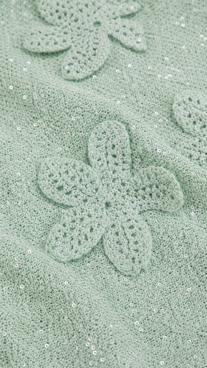 Close-up detail of mint green crochet floral applique and shimmer fabric