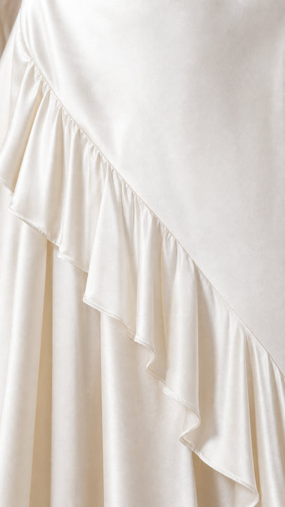 Close-up detail of the satin fabric and ruffle hem