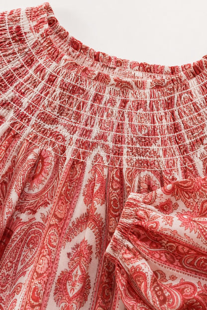 Close up of red paisley print smocked neckline