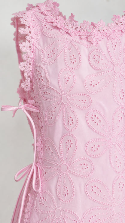 Close-up detail of pink floral eyelet fabric and side tie