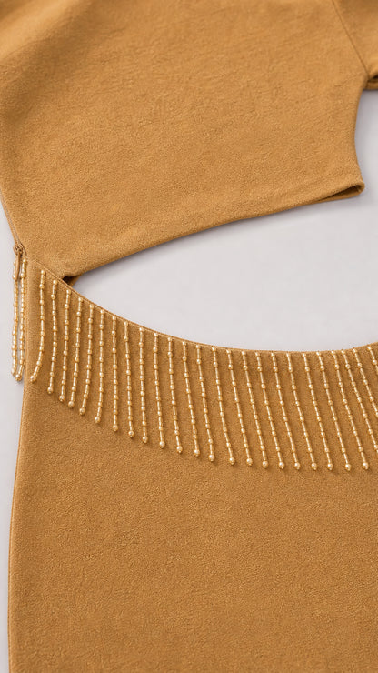 Close-up detail of the waist cutout and beaded fringe trim on the dress