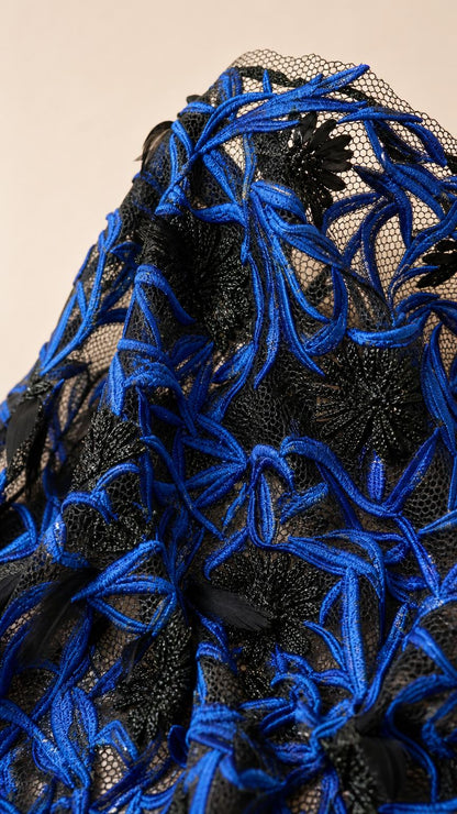 Close up fabric detail of royal blue and black embroidery on mesh