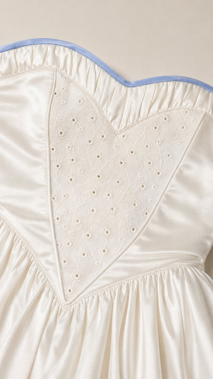 Close-up of heart-embroidered bodice and contrast piping