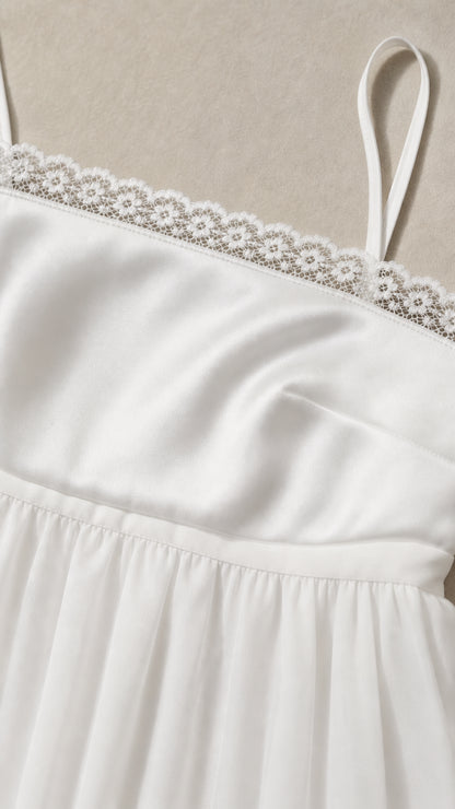 Close-up detail of white fabric and lace trim bodice