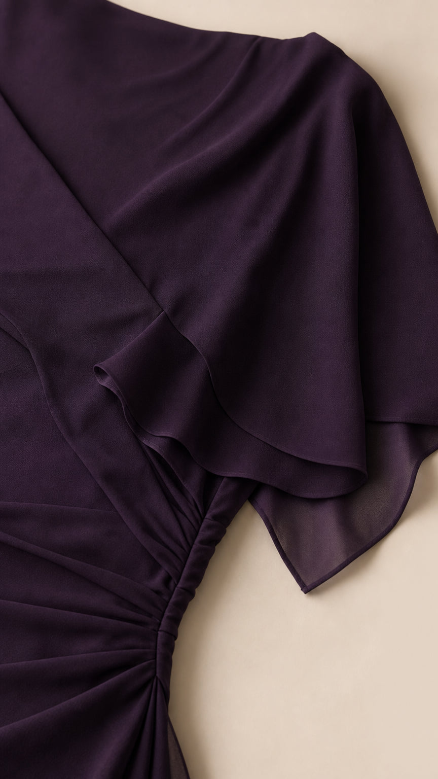 Close-up detail of the draped chiffon fabric and side ruching