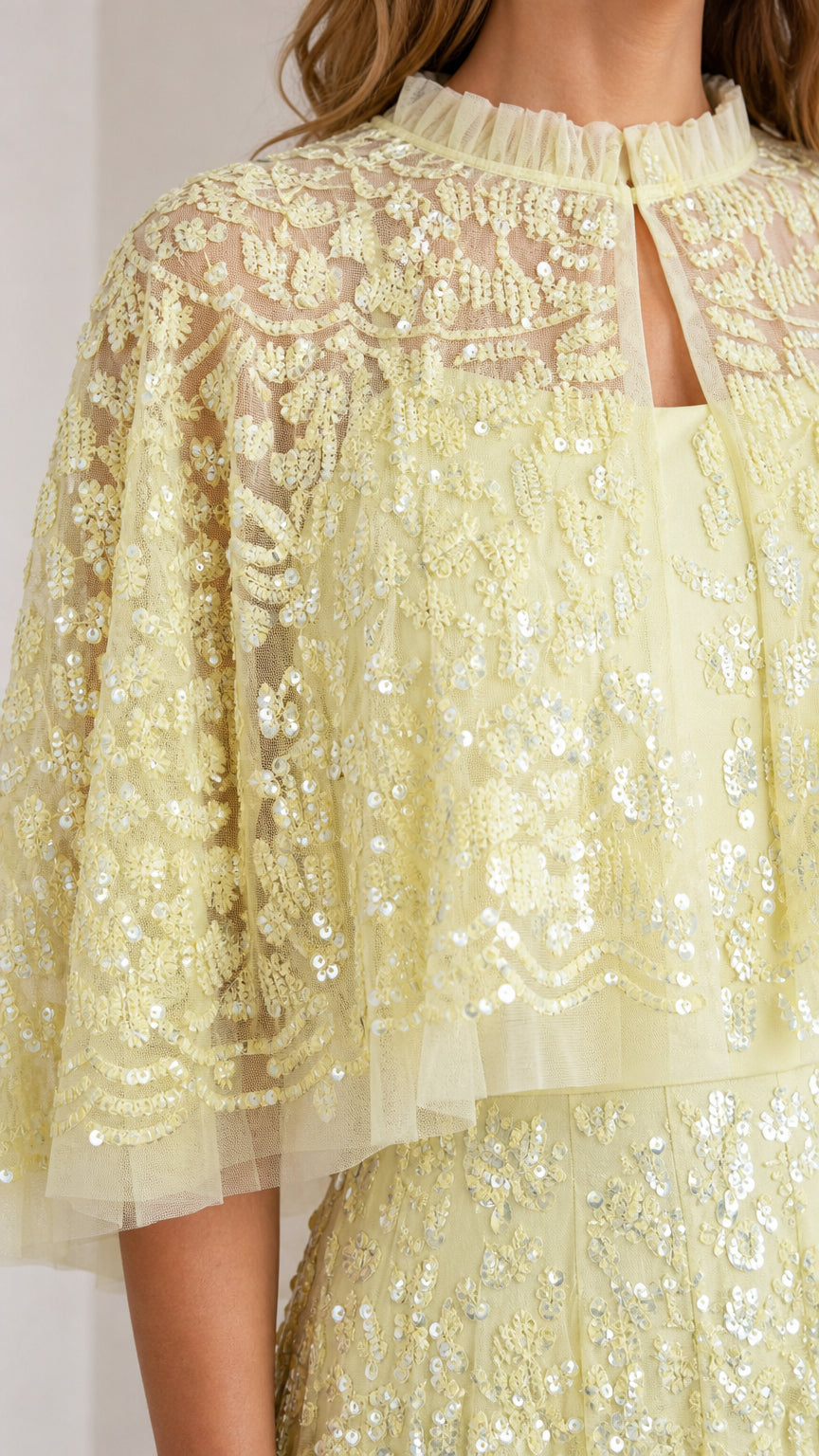 Close-up detail of high neckline and sequin capelet overlay
