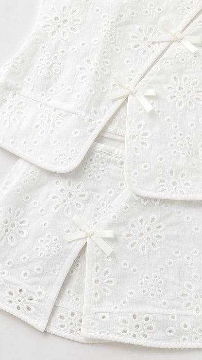 Close-up of white eyelet fabric and bow details